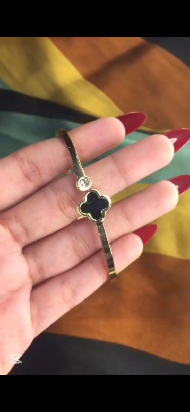 "Elegant Golden Bracelet with Black Clover Design"